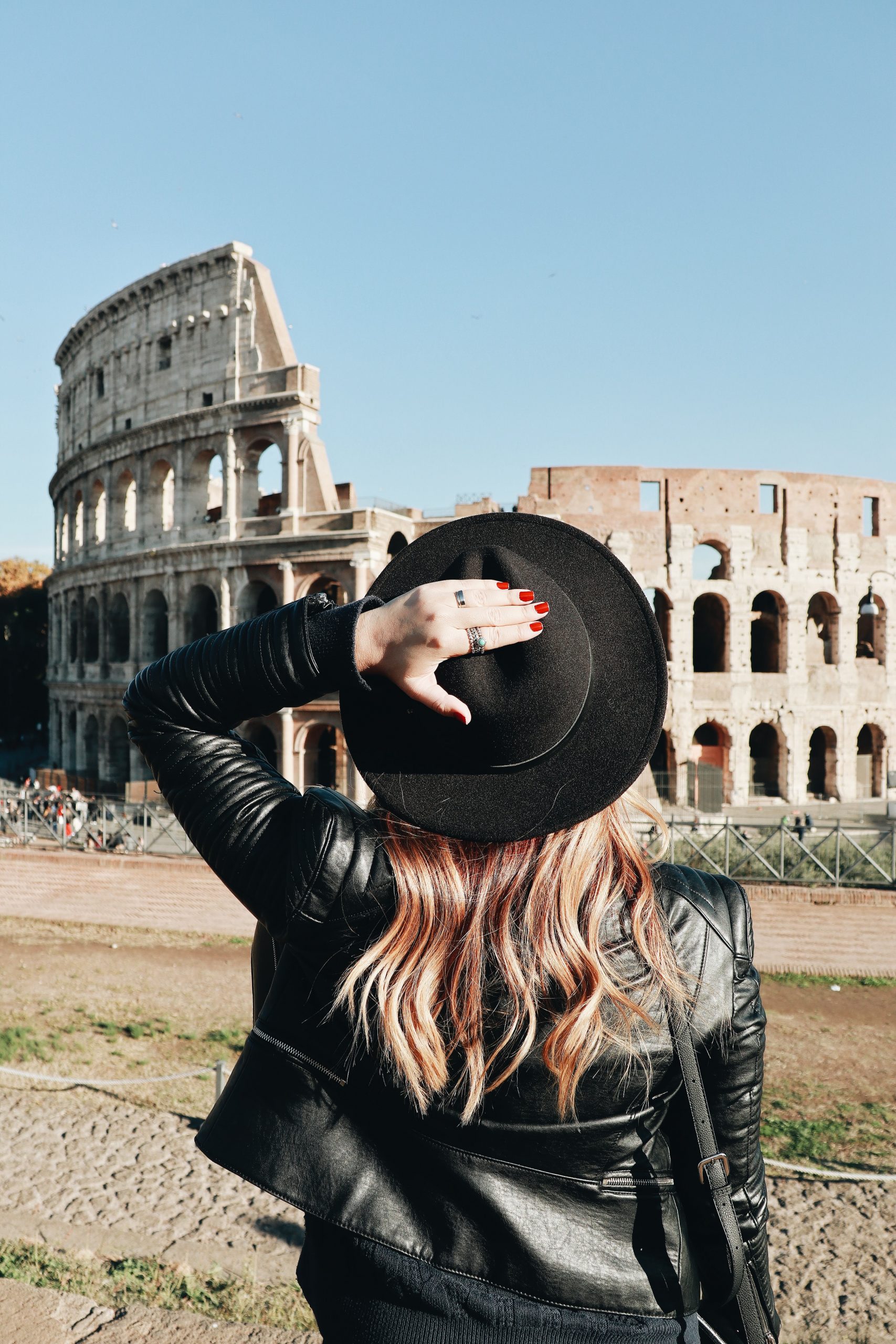 girl looking at the colosseo, thinking about questions to ask moving to italy