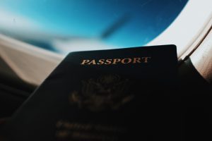 passport in airplane window going to apply for the permesso di soggiorno italy